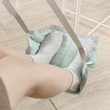 Portable travel footrest for airplane, providing leg support and comfort with adjustable straps and soft fabric.